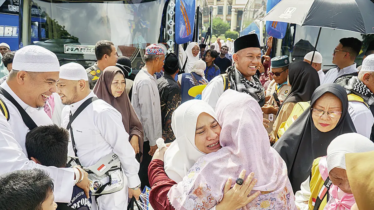 Jemaah Haji asal Kota Pekanbaru memeluk haru anggota keluarganya saat sampai di Kota Pekanbaru setelah menunaikan ibadah haji di Tanah Suci Makkah, Jumat (5/6/2026).(MHD AKHWAN/RIAUPOS)