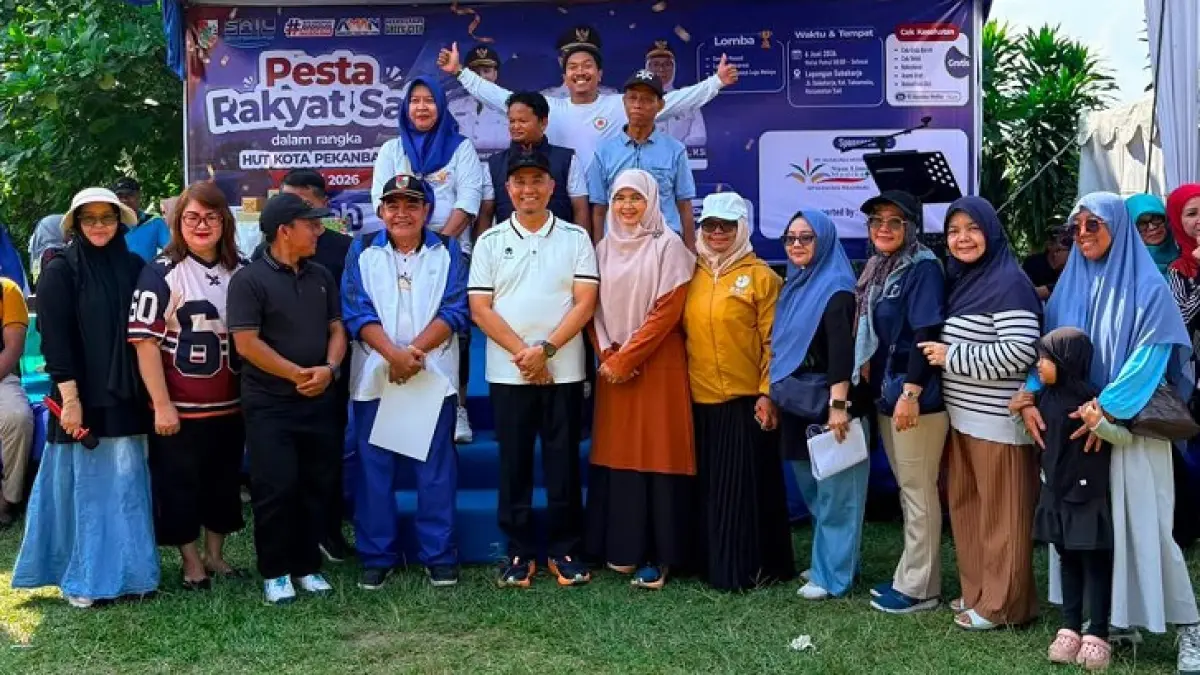 Wawako Pekanbaru H. Markarius Anwar (tengah) didampingi Ketua Tim Penggerak PKK Kota Pekanbaru dr Sari Rahmawati Markarius, (enam kanan) serta Camat Sail Media Nova (lima kanan) foto bersama masyarakat Kecamatan Sail di Lapangan Sukoharjo, Jalan Sukoharjo, Kelurahan Sukamulia, Kecamatan Sail, Sabtu (6/6/2026). (Prapti Dwi Lestari/Riaupos.co)