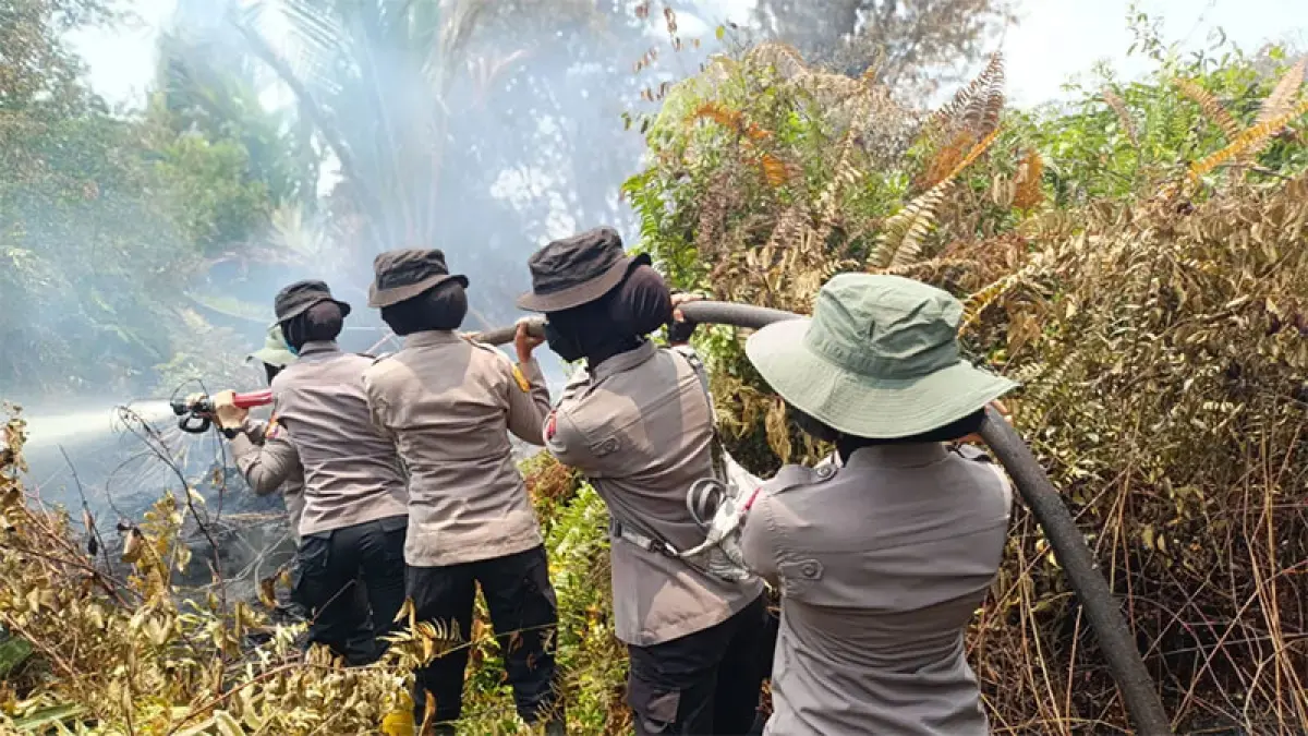 Polwan Polres Bengkalis ikut memadamkan api yang membakar lahan di Desa Sekodi, Kecamatan Bengkalis, belum lama ini. (POLRES BENGKALIS UNTUK RIAUPOS.CO)

