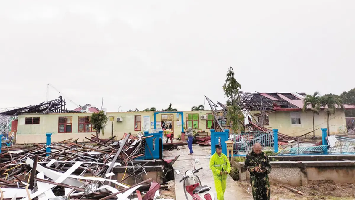Bangunan SMPN 1 Bandar Laksamana, Bengkalis, mengalami kerusakan cukup parah akibat diterjang angin puting beliung yang disertai hujan deras, Ahad (7/6/2026) pagi. Foto atas, terlihat tiang listrik tumbang ke jalan setelah angin puting beliung menerjang permukiman masyarakat di Jalan Lintas Dumai-Pakning, Desa Api-Api, Kecamatan Bandar Laksamana. (Abu Kasim/Riau Pos)
