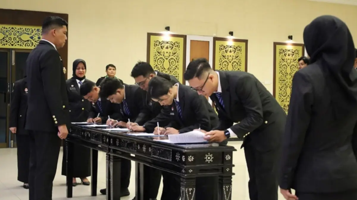 Kepala Kanwil Kemenkum Riau Rudy Hendra Pakpahan (paling kiri) menyaksikan para ASN baru mendatangani berita acara usai diambil sumpah dan dilantik pada Senin (8/6/2026). (Humas Kanwil Kemenkum Riau)