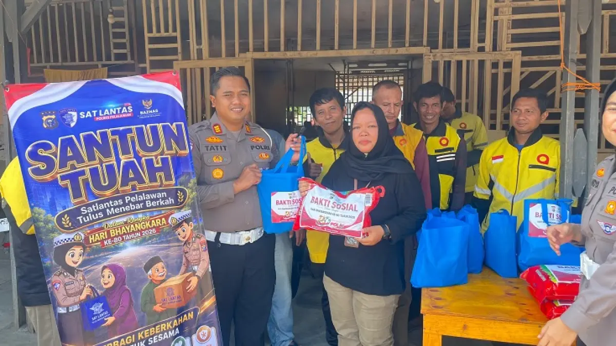Kasatlantas Polres Pelalawan AKP Tatit Rizkyan Hanafi STK SIK MH menyerahkan bantuan sosial kepada para pengemudi ojek online dalam pelaksanaan Polantas Menyapa di Basecamp Maxim Kecamatan Pangkalan Kerinci, Jalan Pemda, Selasa (9/6/2026). (M Amin Amran/Riaupos.co)