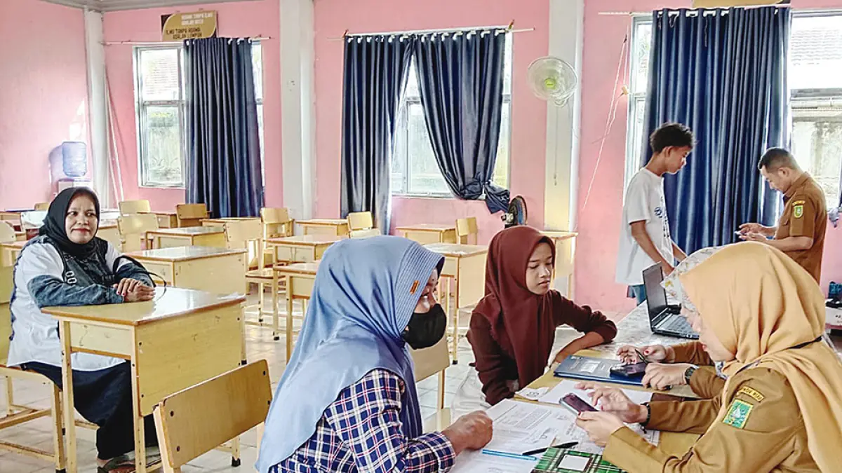 Orang tua murid sedang melakukan proses SPMB tatap muka di SMAN 1 Selatpanjang, Kepulauan Meranti, Senin (8/6/2026). Kendala internet membuat penerimaan murid baru dilakukan secara langsung ke sekolah. (Wira Saputra/Riau Pos)