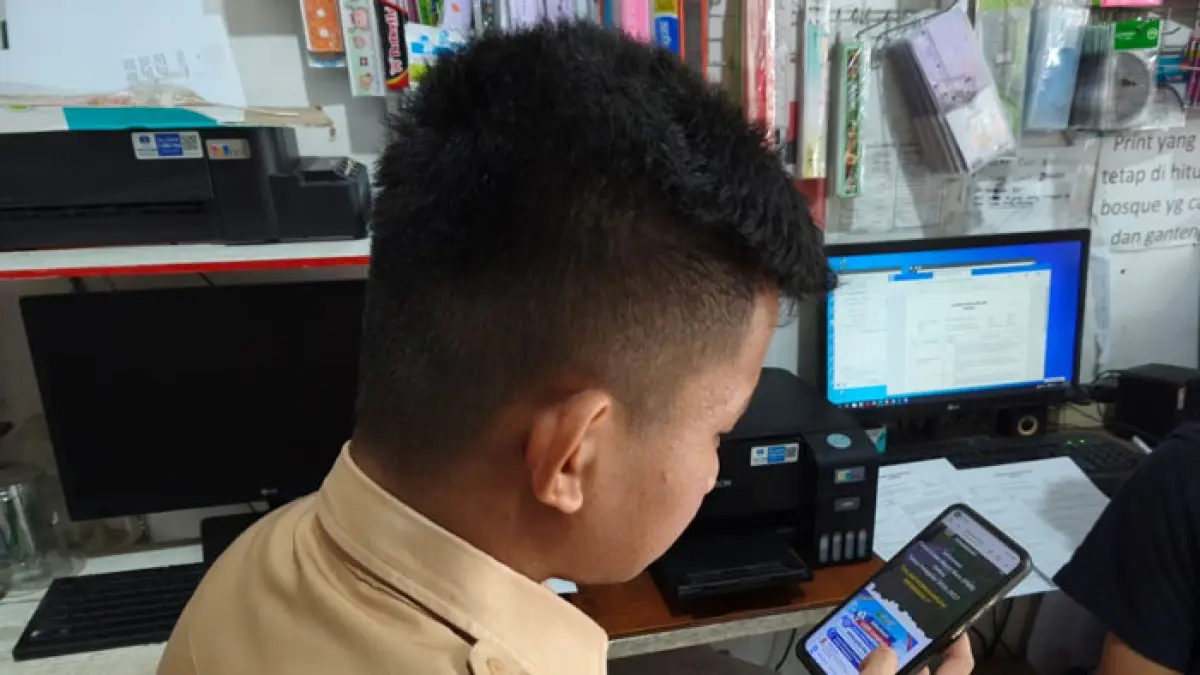 Siswa membuka web sekolah saat SPMB di salah satu tempat penjualan alat tulis kantor di Jalan Delima Pekanbaru, Rabu (10/6/2026). (Evan Gunanzar/Riaupos.co)
