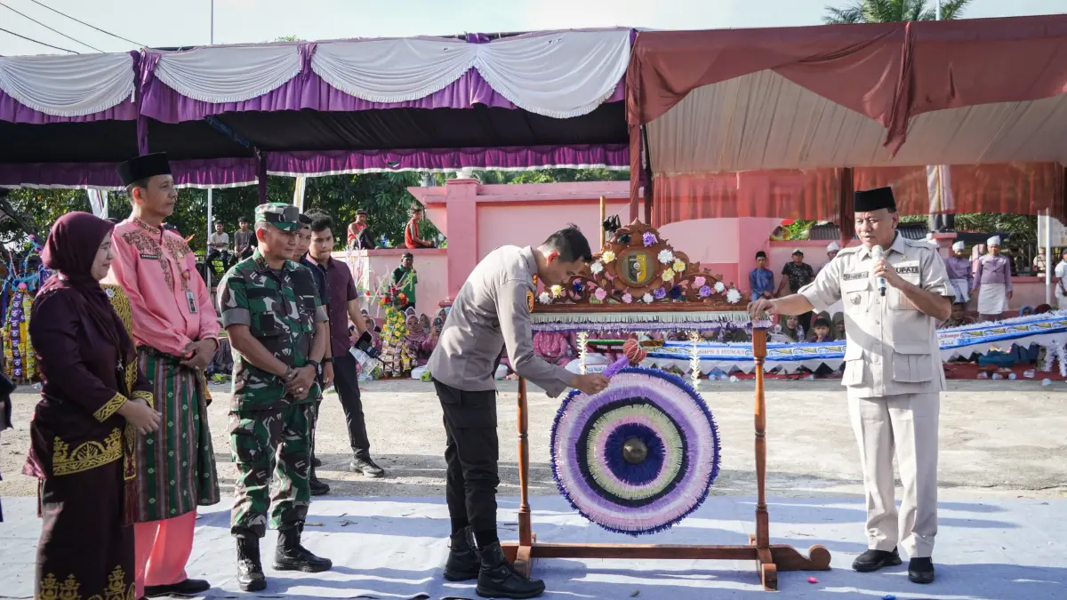 Kapolres Kuansing AKBP Hidayat Perdana SH SIK MH Melakukan pemukulan gong disaksikan Bupati Kuansing Dr H Suhardiman Amby MM dan Kadis Bubpar Ir Emmerson saat membuka pacu jalur Rayon I di Kecamatan Inuman, Kamis (11/6/2026) siang. (Kominfo Kuansing)