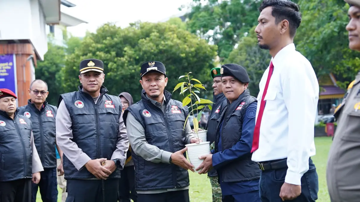 Wali Kota Pekanbaru Agung Nugroho bersama Kapolresta Pekanbaru Kombes Pol Muharman Arta menyerahkan bibit pohon kepada perwakilan peserta Apel Kesiapsiagaan Satgas Anti Narkoba Pekanbaru di halaman MPP Pekanbaru, Jumat (12/6/2026). Pemko pekanbaru untuk riau pos