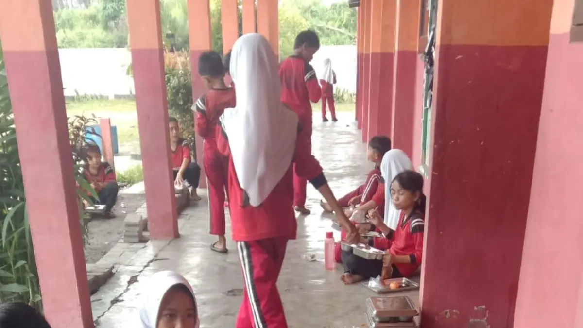 Murid SD 23 Kelurahan Sungai Jering Kecamatan Kuantan Tengah menerima bantuan makan gizi gratis dari SPPG Polres Kuansing, Sabtu (13/6/2026). (Desriandi Candra/RiauPos.co)