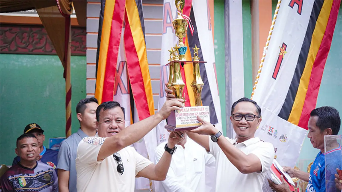 Bupati Kuansing H Suhardiman Amby menyerahkan piala pada pengurus Jalur Alam Cahayo Tuah Naghogi Kecamatan Cerenti yang meraih juara I pada Pacu Jalir Rayon I Kecamatan Inuman, Ahad (14/6/2026). Foto Kominfo Kuansing