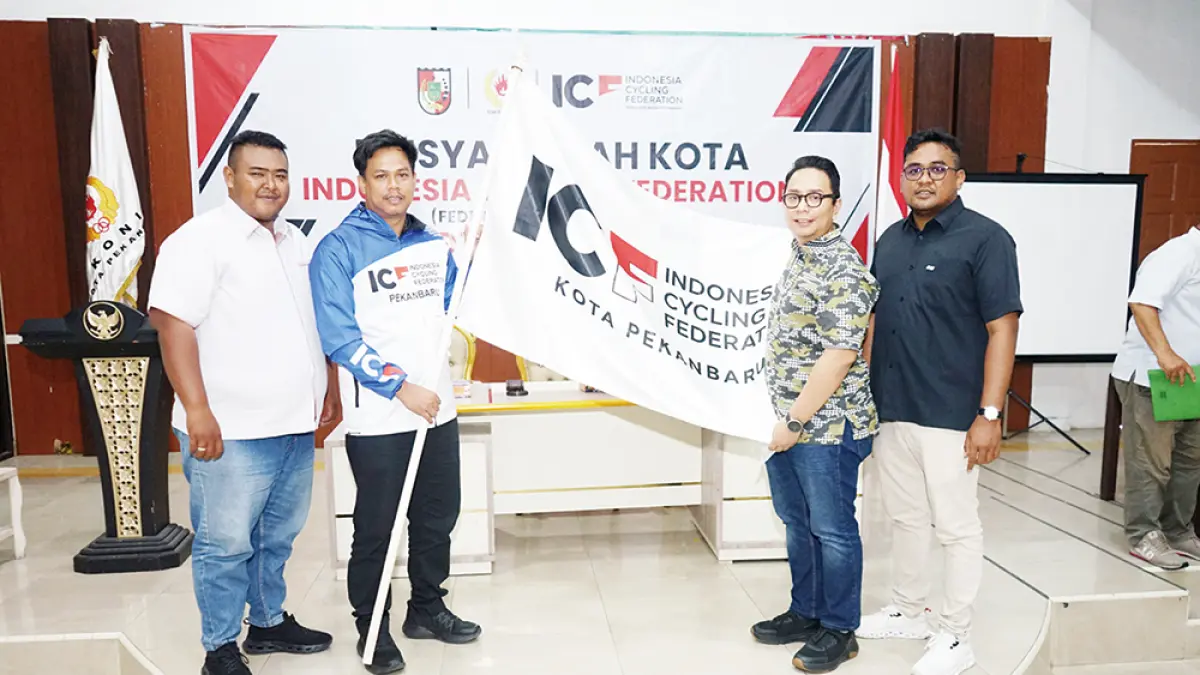 Serahkan Bendera: Sekretaris Umum ICF Riau Muslim Hadi (dua kiri) menyerahkan bendera ICF kepada Ketua ICF Pekanbaru terpilih Afiat Ananda (dua kanan) saat musyawarah Kota ICF di Gedung Dekranasda/KONI Kota, Jalan Arifin Achmad Pekanbaru, Ahad (14/6/2026). (EVAN GUNANZAR/RIAU POS)