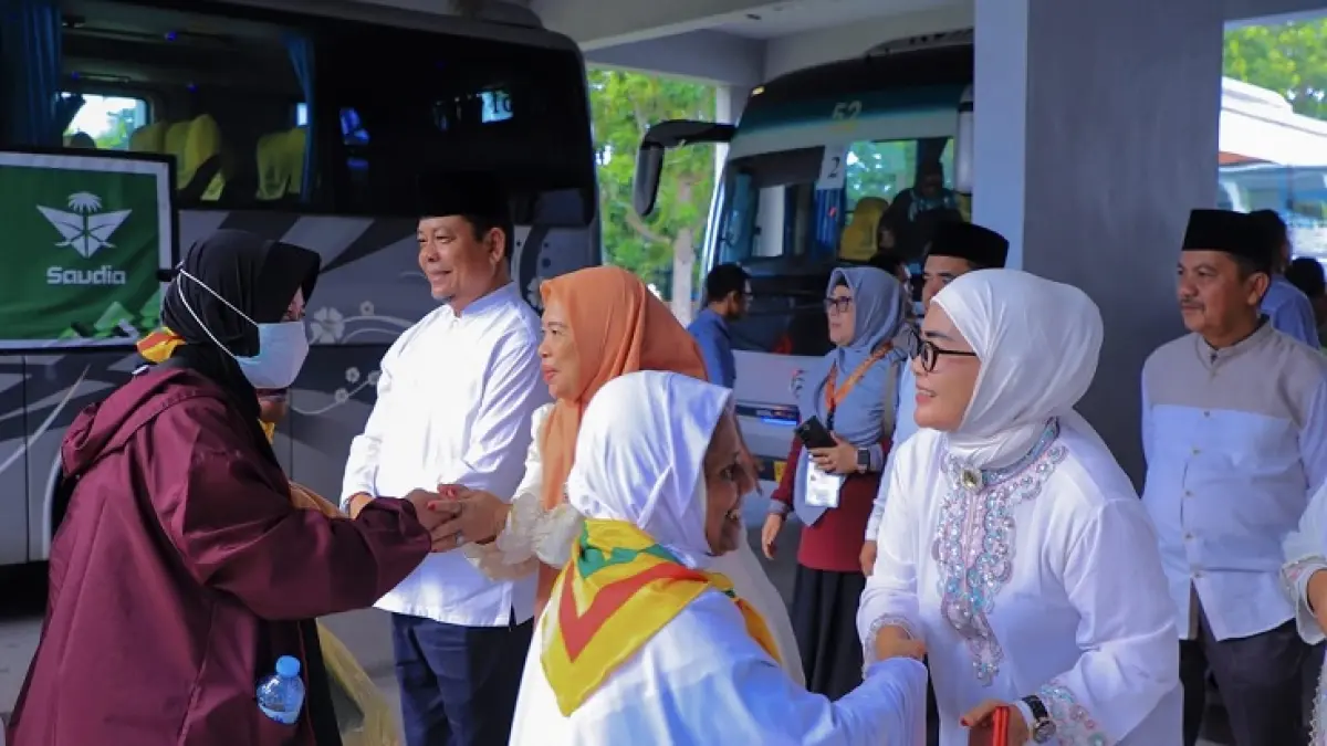 Wabup Rohul H Syafaruddin Poti didampingi istri Hj Masni Taher, Ketua DPRD Rohul Hj Sumiartini menyambut langsung kedatangan 182 Jemaah Haji Rohul Kloter 12 Debarkasi Batam dari Tanah Suci saat turun bus menuju Asrama Haji Batam, Senin (15/6/2026) petang. (Prokopim Setda Rohul untuk Riaupos.co)