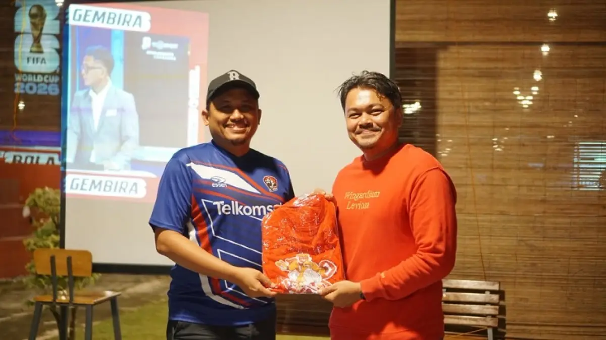 Manager Mobile Consumer Branch Pekanbaru, Albeno Saleh Ahmad (kiri foto) menyerahkan merchandise kepada pemenang quiz (kanan) pada acara Nonton Bareng Bola Gembira MAXStream TV di MatKopi Pekanbaru (12/6/2026). (Istimewa)