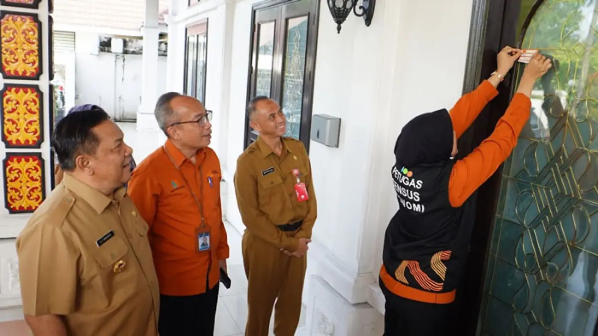 Plt Gubri SF Hariyanto menyaksikan penempelan stiker usai didata oleh petugas sensus Ekonomi, Senin (15/6/2026). (Diskominfo Riau untuk Riaupos.co)
