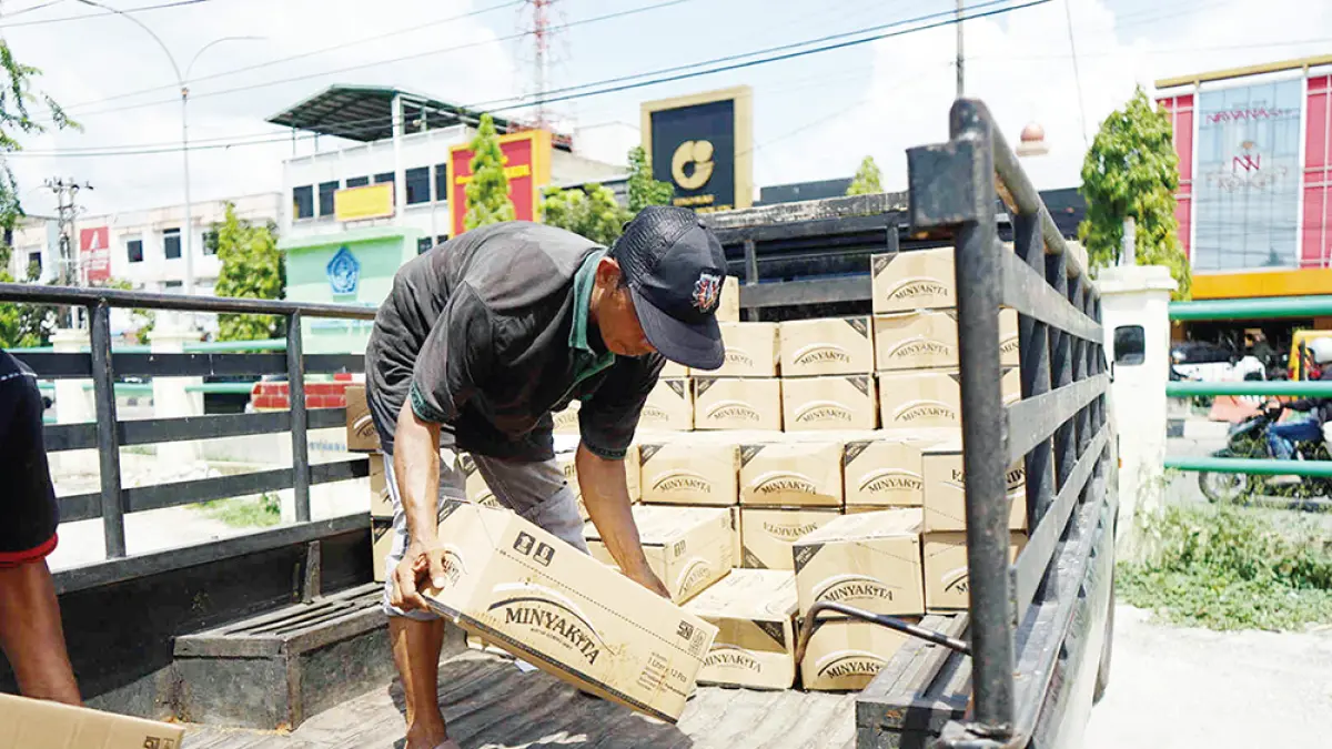 Buruh angkut menyusun  kar­dus-kardus berisi minyak goreng subsidi Mi­nyakita saat didistribusikan ke kios peda­gang Pasar Cik Puan Pekanbaru, belum lama ini. (EVAN GUNANZAR/RIAU POS)