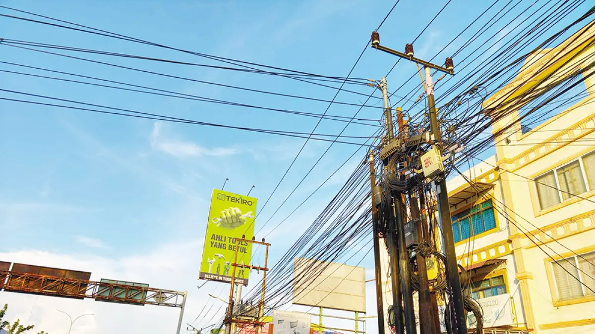 SEMRAWUT: Kondisi kabel telekomunikasi atau fiber optik (FO) yang semrawut di Jalan Tuanku Tambusai Pekanbaru, Selasa (16/6/2026). Kalangan DPRD Pekanbaru meminta Pemko Pekanbaru untuk segera menerapkan kebijakan menanam kabel FO di bawah tanah. (EVAN GUNANZAR/RIAU POS)