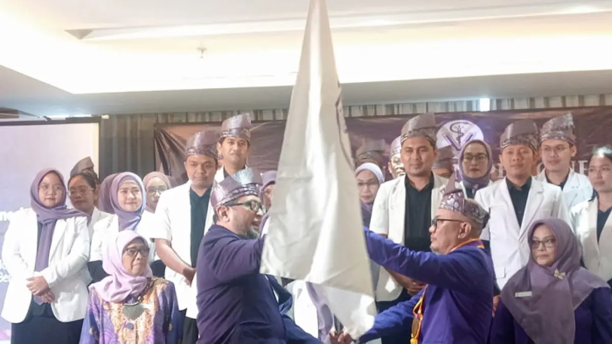 Ketua PDHI cabang Riau masa bakti 2026-2030 drh Harjono MM (kanan) menerima bendera pataka yang diberikan Sekjen PB PDHI drh Andi Wijanarko, MM (kiri) saat pelantikan pengurus PDHI Cabang Riau di Novotel Pekanbaru, Kamis (18/5/2026). (Prapti Dwi Lestari/Riaupos.co)