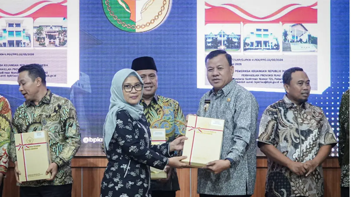 Direktur Pengelolaan Pemeriksaan VII Direktorat Jenderal Pemeriksaan Keuangan Negara V, Dr Juska Meidy Enyke Sjam menyerahkan penghargaan WTP pada Bupati Kuansing Dr H Suhardiman Amby MM di Auditorium BPK RI Perwakilan Riau di Pekanbaru, Kamis (18/6/2026). FOTO Kominfo Kuansing