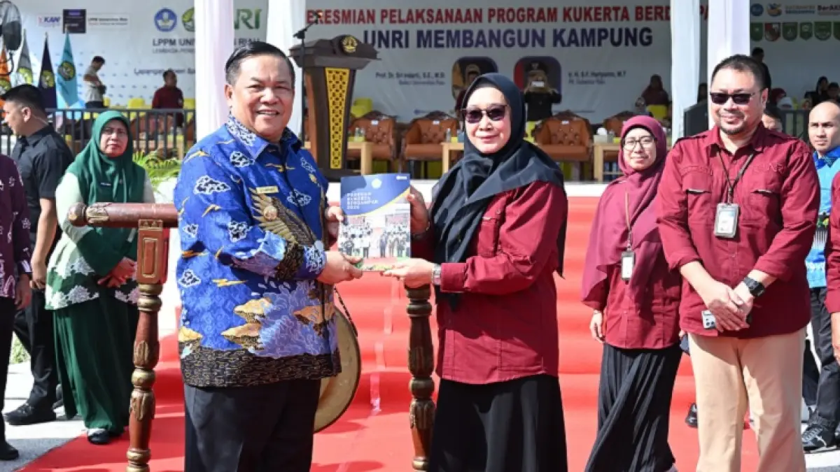 Rektor Unri&nbsp;Prof Dr Sri Indarti SE MSi dan Plt Gubernur Riau Ir SF Hariyanto MT memperlihatkan buku panduan Kukerta usai penyerahan mahasiswa Kukerta, Kamis (18/6/2026). (Humas Unri untuk Riau Pos)
