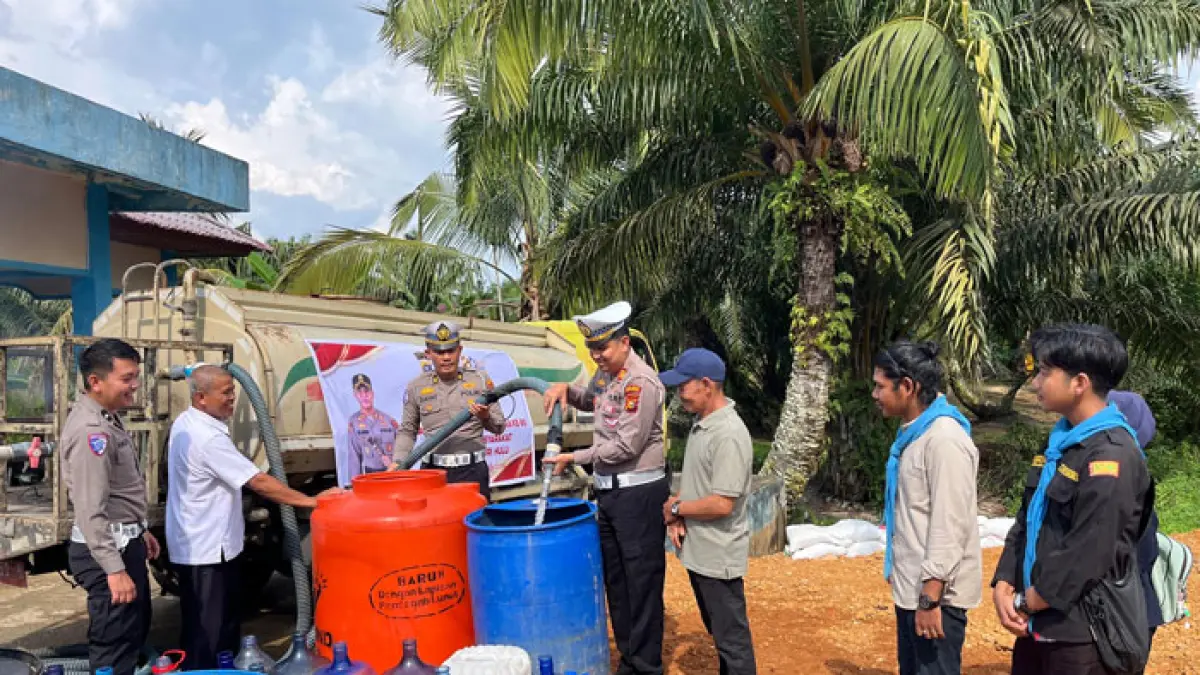 Kasat Lantas Polres Inhu, AKP Fikri Kurniawan saat mengisi drum penampungan saat menyalurkan bantuan air bersih di Kelurahan Sekip Hilir, Jumat (19/6/2026). (Satlantas Polres Inhu untuk Riaupos.co)