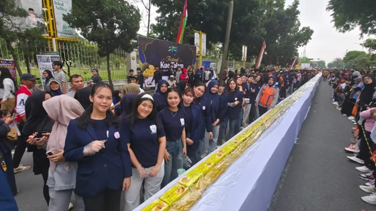 Sejumlah mahasiswa President University Pekanbaru turut berpartisipasi&nbsp; menyiapkan kue talam ketan durian sepanjang 150 meter di Kawasan CFD Jalan Jenderal Sudirman Pekanbaru, Ahad (21/6/2026).(Prapti Dwi Lestari/Riaupos.co)