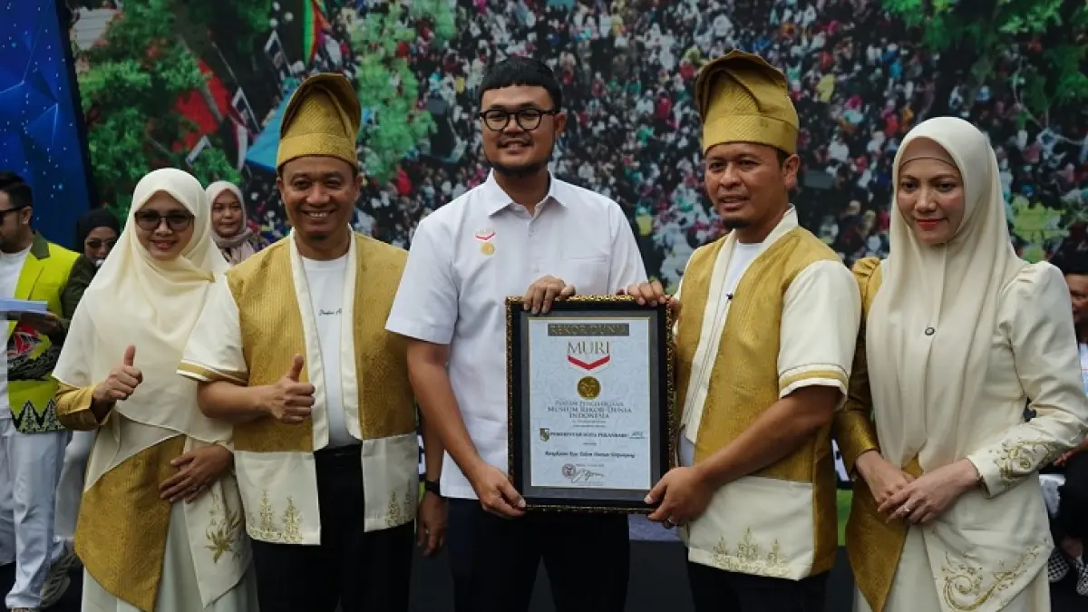 Wali Kota Pekanbaru Agung Nugroho (dua kanan) bersama Wawako Pekanbaru Markarius Anwar (dua kiri), Ketua TP PKK Pekanbaru Sulastri Agung (kanan), Ketua I TP PKK Pekanbaru Sari Rahmawati Markarius (kiri) menerima rekor MURI saat Festival Kue Talam Ketan Durian di Pekanbaru, Ahad (21/6/2026). (EVAN GUNANZAR/RIAU POS)