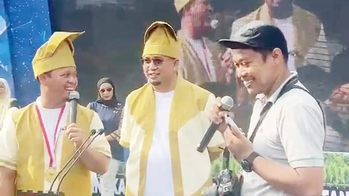 DAPAT HADIAH: Fotografer Riau Pos, Evan Gunanzar  (kanan), mendapatkan hadiah umrah dari Wali Kota Pekanbaru Agung Nugroho (kiri) yang turut dihadiri Wakil Ketua Komisi VI DPR RI Andre Rosiade (tengah) di iven pemecahan rekor MURI kue talam terpanjang, Ahad (21/6/2026). (prapti dwi lestari/riau pos)
