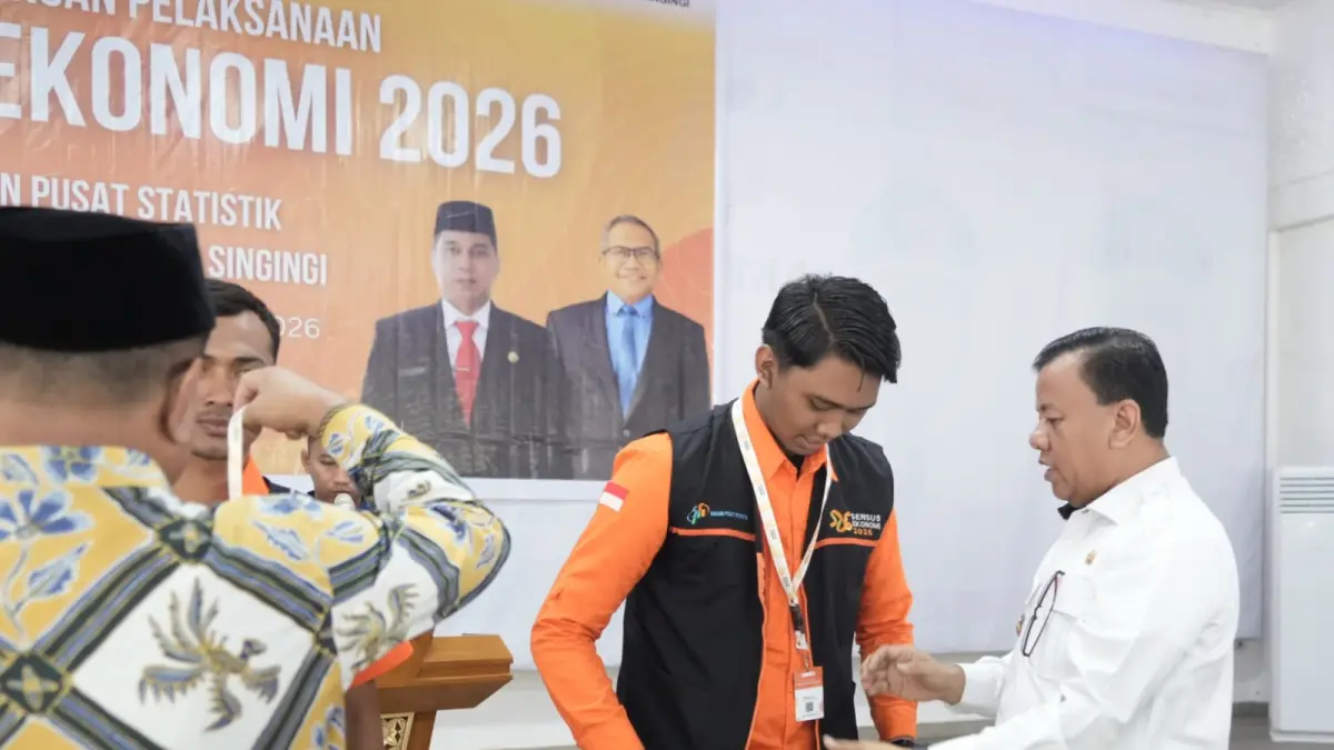 Bupati Kuansing Dr H Suhardiman Amby MM memasangkan tanda pengenal petugas sensus ekonomi saat pencanangan, Rabu (24/6/2026).(DESRIANDI CANDRA/RIAUPOS.CO)