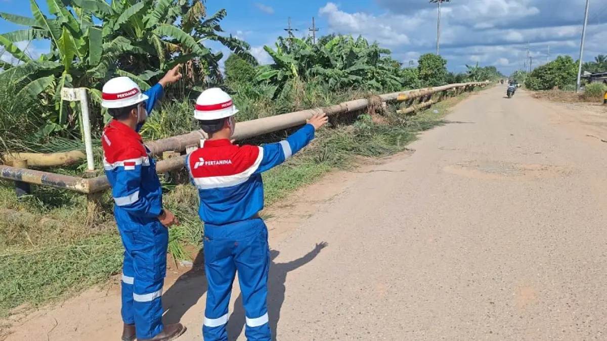 Dua pekerja PT Pertamina Hulu Rokan saat menunjukan area Jalan Lintas Pinang Kubu, Kabupaten Rohil, Provinsi Riau yang akan diperbaiki. (PHR Untuk Riaupos.co)