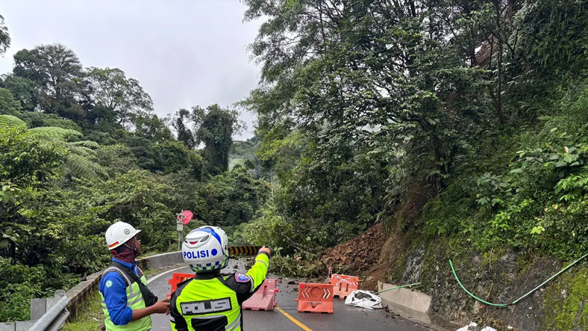 Personel Ditlantas Polda Sumbar memasang barikade untuk menutup jalan akibat longsor di jalur Padang–Bukittinggi Km  66+700 Lembah Anai, Kabupaten Tanah Datar, Provinsi Sumatera Barat, Rabu (24/6/2026) siang. (DITLANTAS POLDA SUMBAR)