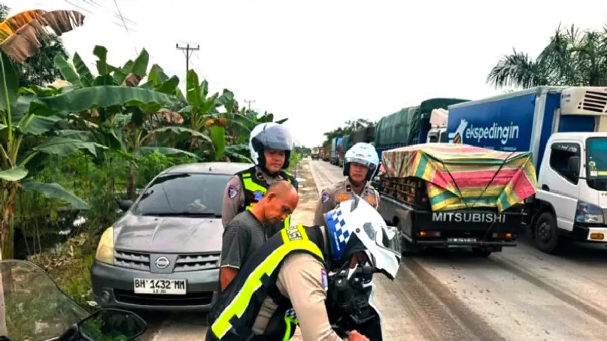 Personel Sat Lantas Polres Pelalawan memberikan sanksi tegas berupa penilangan terhadap penerobos yang menyebabkan kemacetan panjang di Jalintim KM 75 Kelurahan Pangkalan Kerinci Timur Kecamatan Pangkalan Kerinci, Kamis (25/6/2026). (Amin/Riaupos.co)