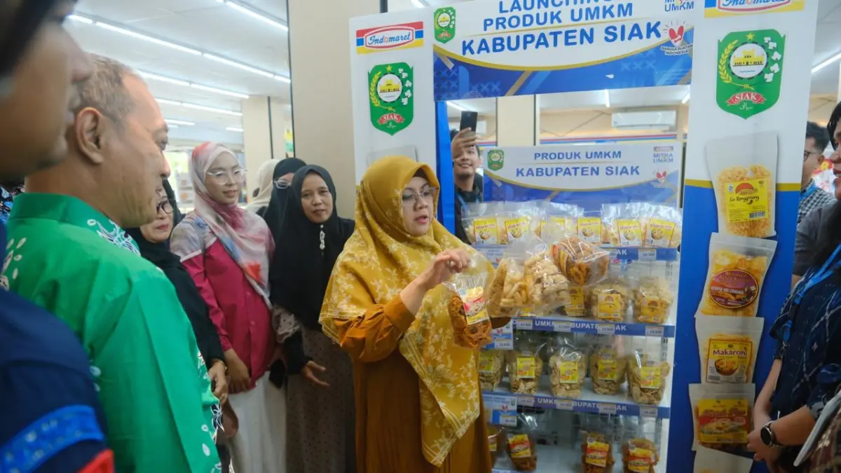 Bupati Afni Z memperlihatkan produk UMKM Siak dipajang di Indomaret usai penandatanganan kesepakatan bersama antara Pemerintah Kabupaten Siak, PT Indomarco Prismatama dan Perkumpulan UMKM Mitra Indomaret yang dirangkai dengan peluncuran program UMKM Mitra Indomaret di Jalan Sutomo Siak Kota, Kamis (25/6/2026).(DISKOMINFO SIAK UNTUK RIAUPOS.CO)