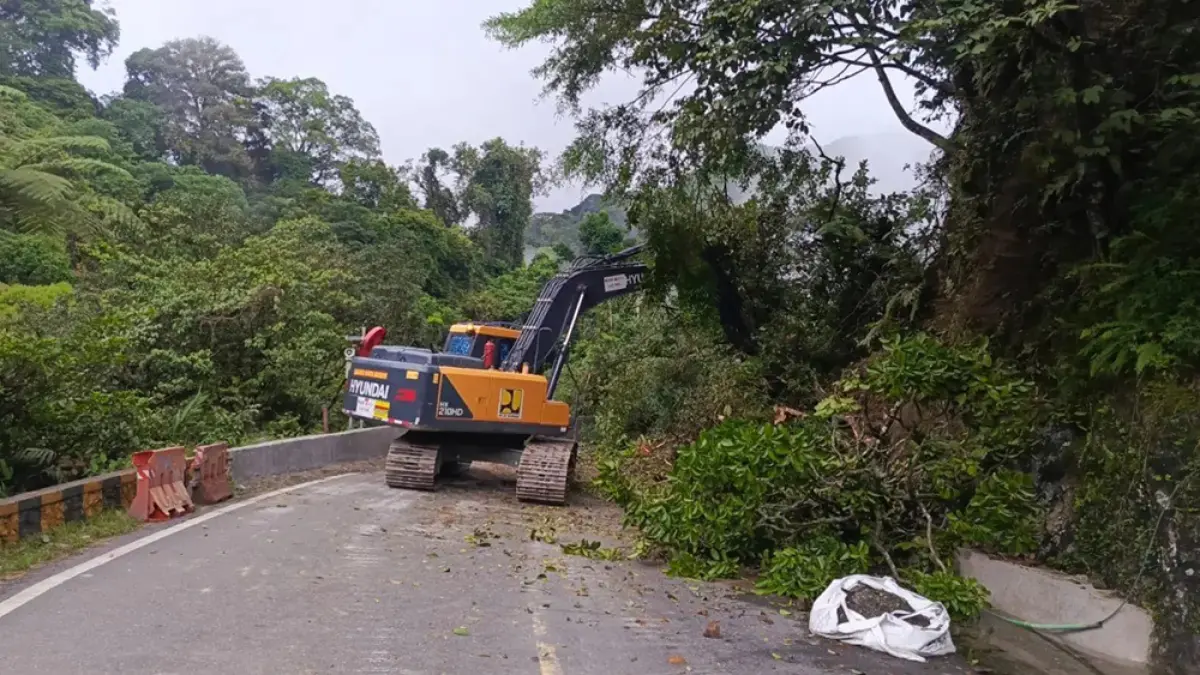 Petugas mengoperasikan alat berat untuk membersihkan material longsor dan batu besar yang sempat menutup badan jalan di kawasan Lembah Anai, Tanahdatar, Sumatera Barat, Rabu (24/6/2026). (RPG)
