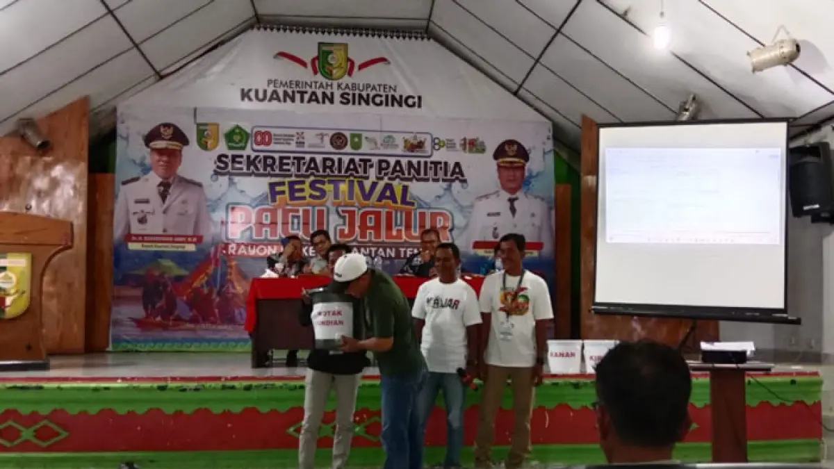 Seorang urusan jalur mengambil pencabutan undian perpacuan jalur Rayon II, Jumat (26/6/2026) di gedung Narosa Teluk Kuantan. (Desriandi Candra/Riaupos.co)
