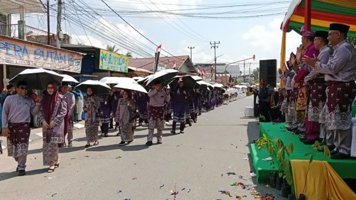 Sekda Kuansing Zulkarnain ST MSi bersama istri, Asisten III Drs Azhar MM bersama istri memimpin pawai taaruf kafilah Kabupaten Kuansing saat pembukaan MTQ Riau, Sabtu (27/6/2026) di ruas Jalan Simpang Tiga-A Yani Teluk Kuantan. (Desriandi Candra/Riaupos.co)
