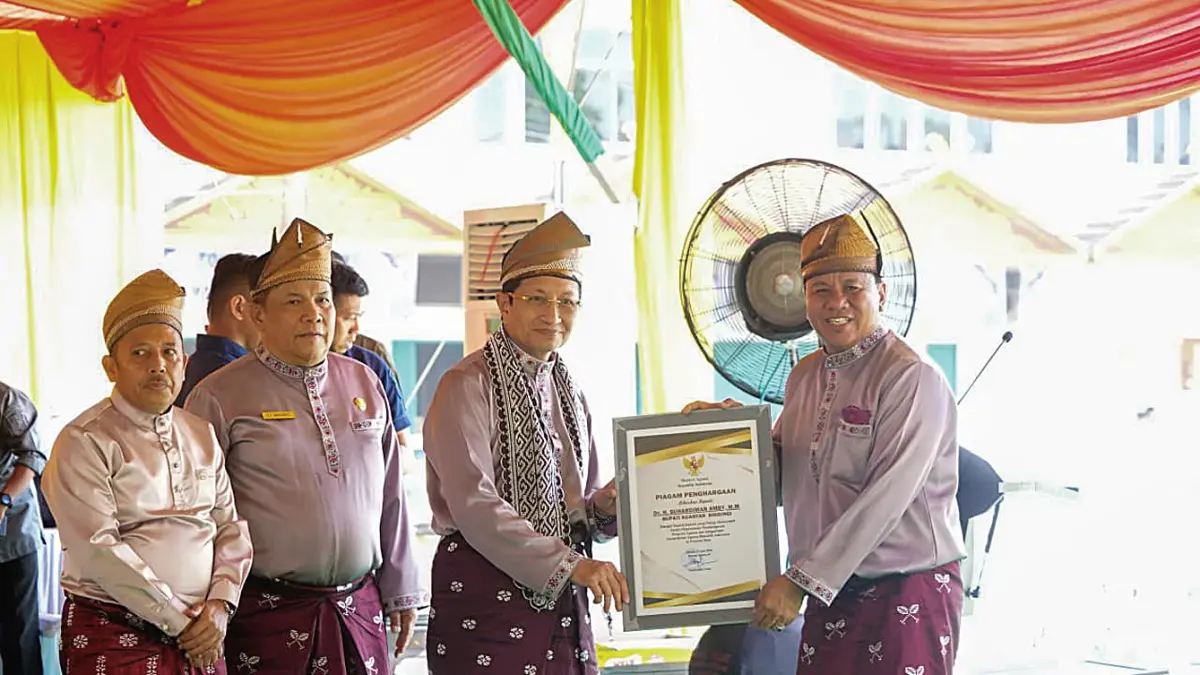 Menteri Agama RI, Prof Dr KH Nasaruddin Umar MA, menyerahkan penghargaan kepada Bupati Kuansing Dr H Suhardiman Amby MM usai pawai taaruf MTQ Riau di Astaka Utama MTQ Riau, Sabtu (27/6/2026). Turut hadir Plt Gubernur Riau SF Hariyanto (dua kiri) dan Kakanwil Kemenag Riau Muliardi (paling kiri).