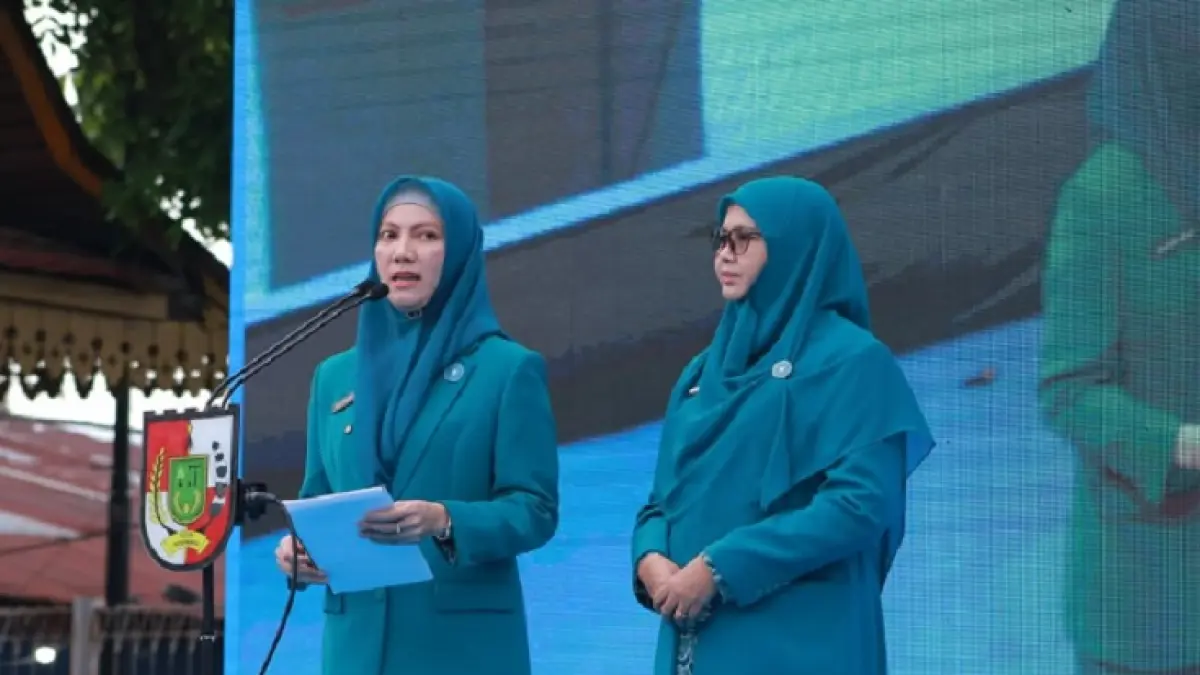 Ketua TP PKK Pekanbaru Sulastri Agung dan Ketua I TP PKK Pekanbaru Sari Rahmawati memberikan sambutan di depan ratusan kader PKK Pekanbaru dalam puncak peringatan Hari Kesatuan Gerak (HKG) PKK ke-54 Kota Pekanbaru yang digelar di Lapangan Bukit Senapelan, Senin (29/6/2026). (Istimewa)