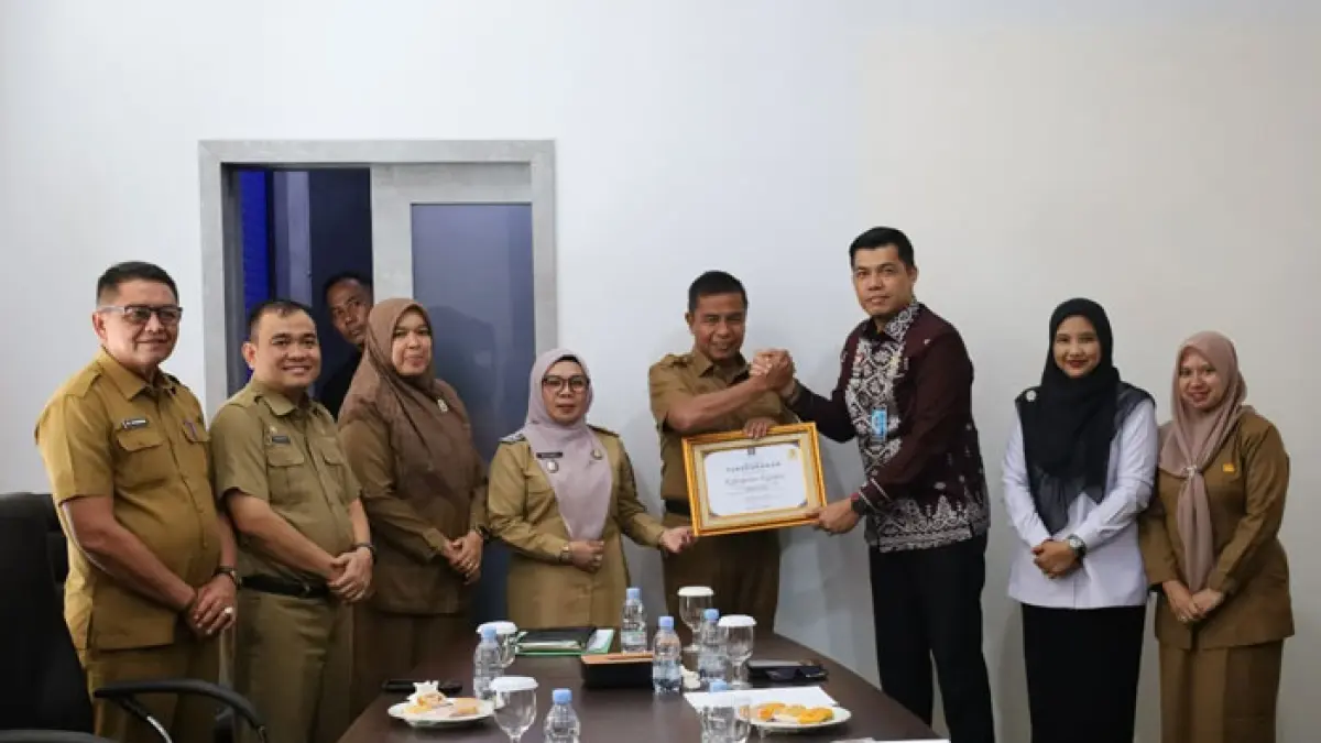 Kepala Kanwil Kemenkum Riau Rudy Hendra Pakpahan (tiga dari kanan) menyerahkan piagam penghargaan JDIH kepada Bupati Kampar Ahmad Yuzar pada Senin (29/6/2026).(Humas Kanwil Kemenkum Riau untuk RiauPos.co)