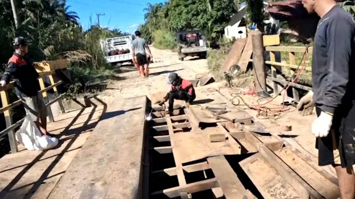 Seorang pekerja sedang mengelas plat lantai Jembatan Desa Pasir Utama, Kecamatan Rambah Hilir yang sebelumnya mengalami kerusakan dan berlubang, Rabu (1/7/2026). (Dinas PUPR Rohul untuk Riaupos.co)