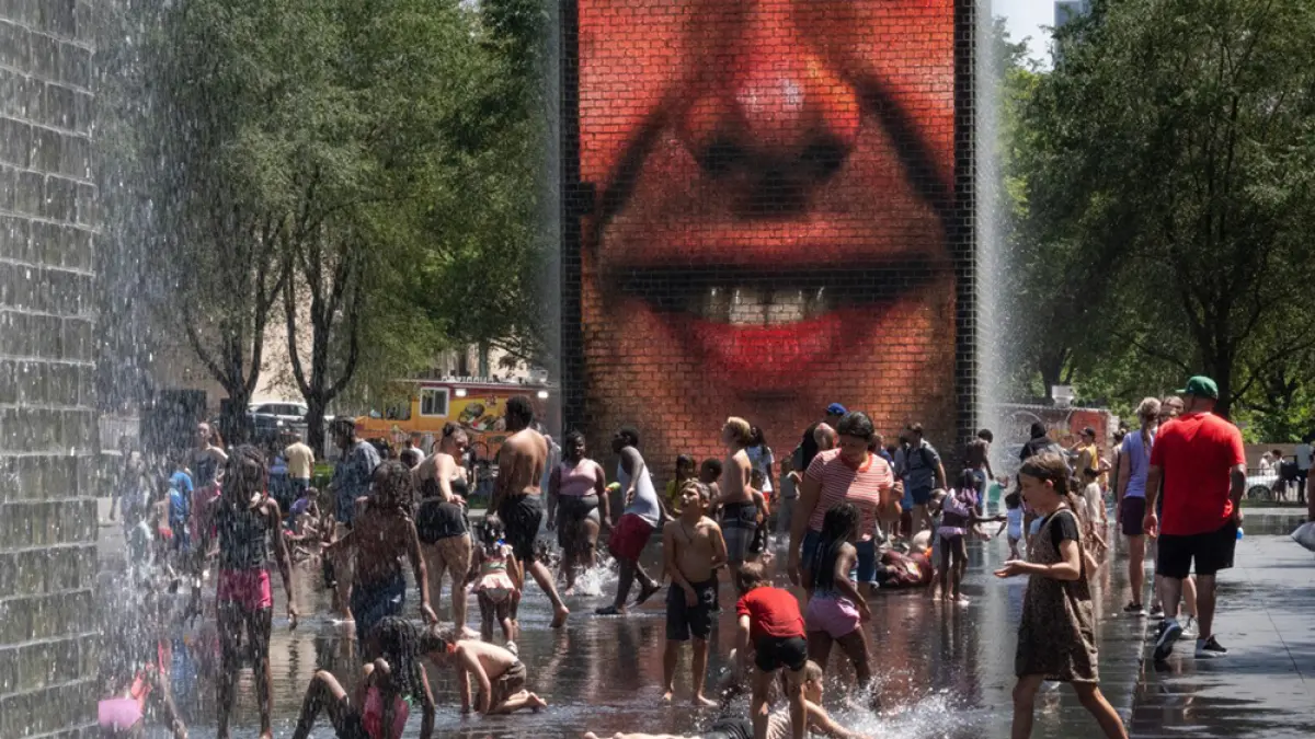 Warga menyejukkan diri dengan mandi air pancuran di Crown Fountain, Millennium Park, Chicago, Illinois saat suhu udara melampaui 90 derajat Fahrenheit (sekitar 32 derajat Celsius), Senin (29/6/2026). (AFP)