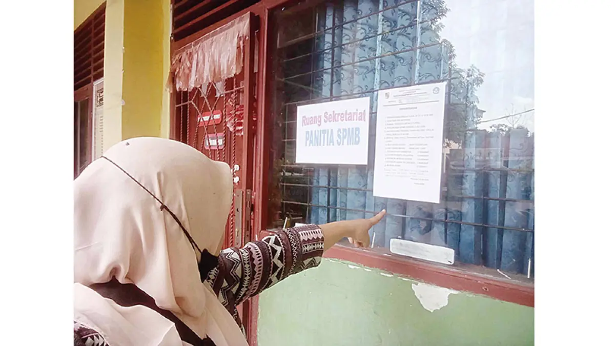 LIHAT PENGUMUMAN: Calon wali murid melihat pengumuman penerimaan murid baru di SDN 109 Jalan Purnama Sari, Kecamatan Bukit Raya, Pekanbaru, Rabu (1/7/2026). (EVAN GUNANZAR/riau pos)
