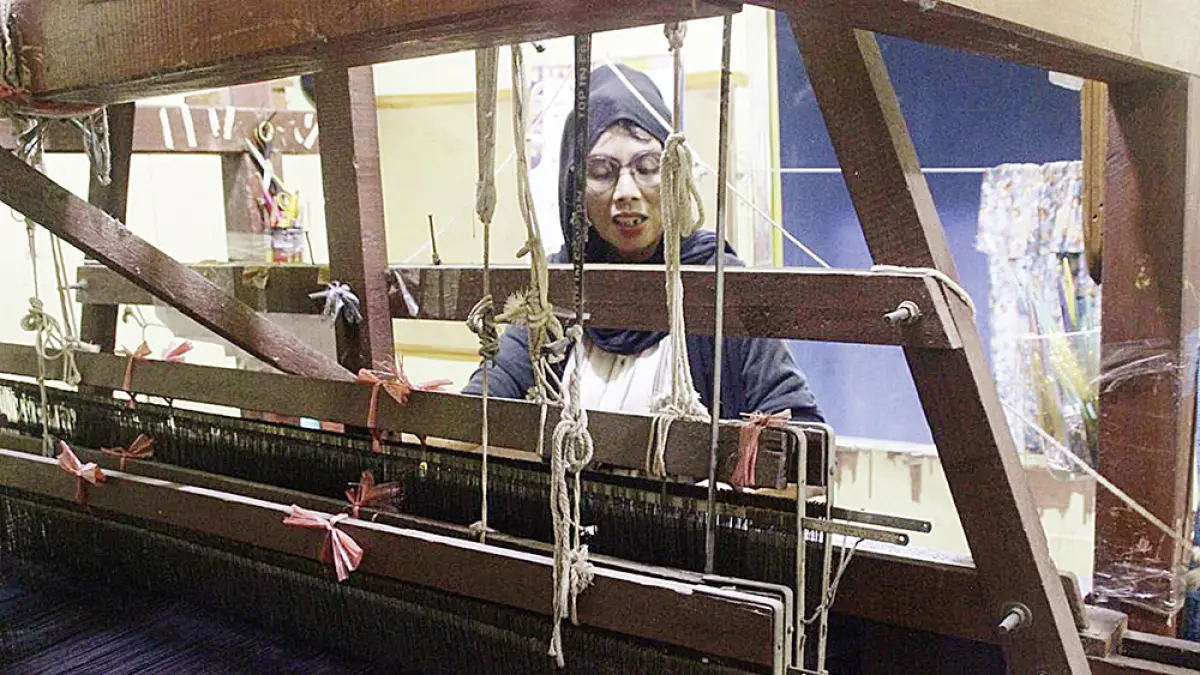 ALAT TENUN: Ruhaya saat menggerakkan alat tenun tradisional di Rumah Tenun Pucuk Rebung Kampung Bandar, belum lama ini. (foto Ajeng Revina Putri untuk riau pos)
