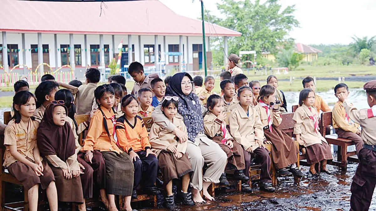 Bupati Siak Afni Z merangkul salah satu murid saat foto bersama usai membagikan seragam gratis kepada murid SD di Dusun Mungkal, Desa Penyengat, Kecamatan Sungai Apit, Kamis (21/5/2026). (diskominfo siak untuk riau pos)