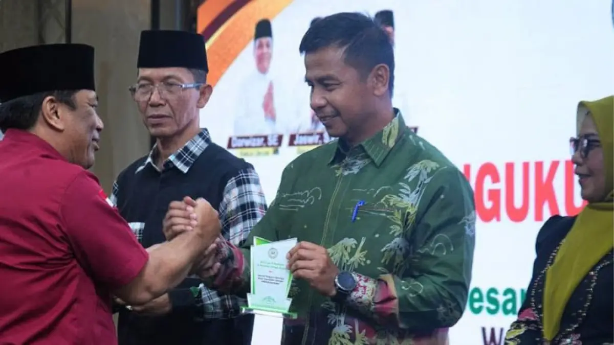 Bupati Kampar Ahmad Yuzar salam komando dengan Darwira Ketua Umum Keluarga Besar Kabupaten Kampar (KBKK) Kota Batam masa bakti 2026–2031  di Ballroom Hotel Golden View Bengkong, Batam, Sabtu (4/7/2026). (Diskominfo Kampar untuk Riaupos.co)