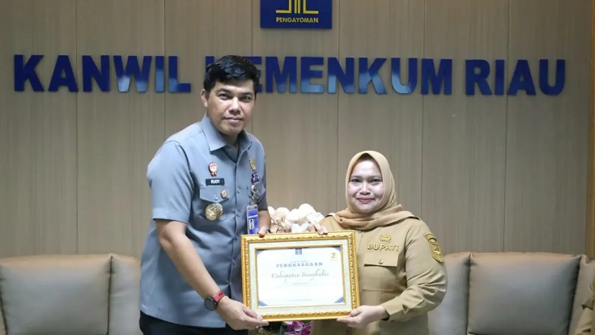 Kepala Kanwil Kemenkum Riau Rudy Hendra Pakpahan menyerahkan&nbsp; Sertifikat Penghargaan JDIH Terbaik II tingkat Provinsi Riau Tahun 2026 kepada Bupati Bengkalis Kasmarni, Senin (6/7/2026). (Humas Kanwil Kemenkum Riau)