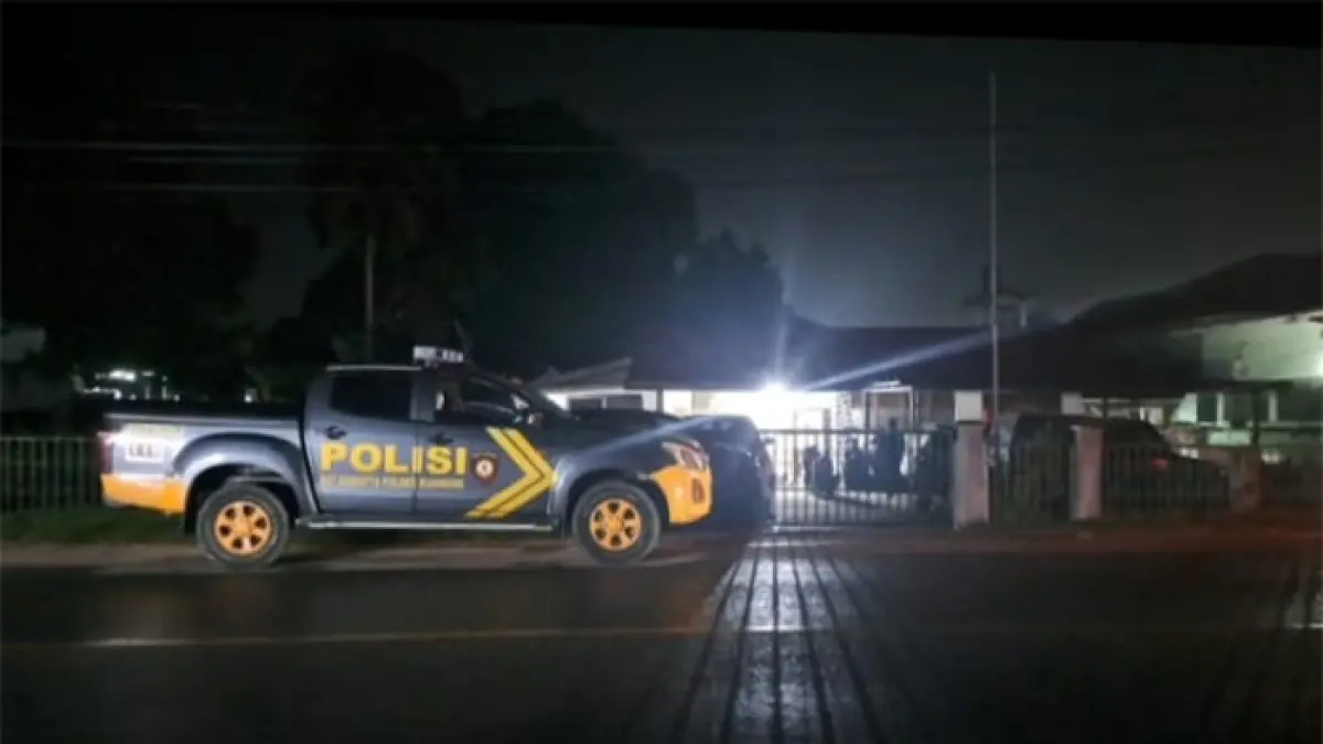 Mobil polisi berjaga di depan rumah Kepala Dinas Perkebunan dan Peternakan Kuansing ANY, Ahad (5/7/2027). (Istimewa)