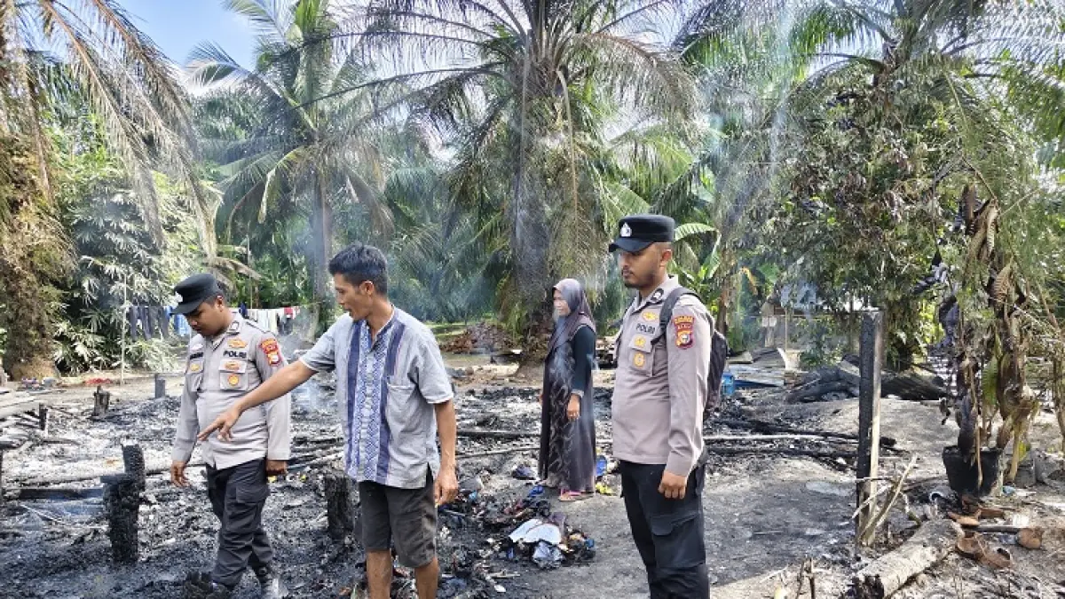 Personel Polsek Kubu melihat kondisi pascakebakaran rumah di wilayah Kepenghuluan Teluk Piyai Pesisir, Kubu, Senin (6/7/2026). (Polsek Kubu untuk Riaupos.co)