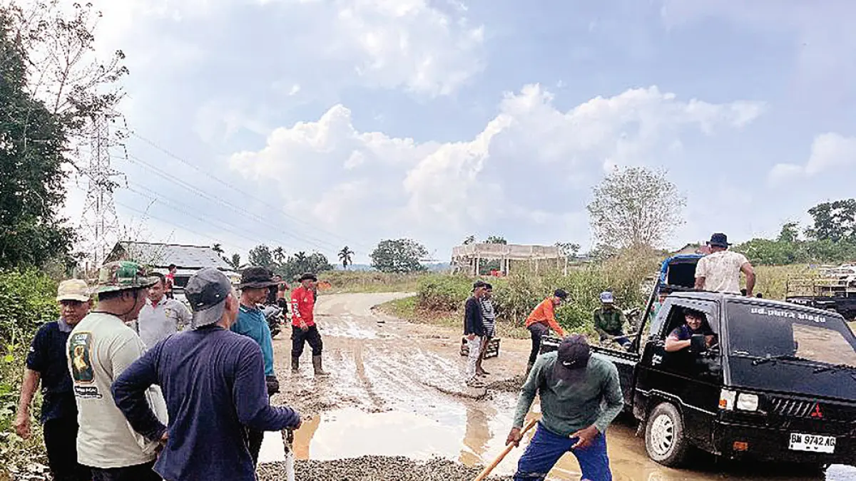PERBAIKI JALAN: Warga bersama Pemerintah Desa Koto Mesjid bergotong royong memperbaiki jalan secara swadaya di sejumlah titik wilayah Koto Mesjid, Kecamatan XIII Koto Kampar, Kabupaten Kampar, Ahad (5/7/2026). (Warga untuk Riau Pos)

