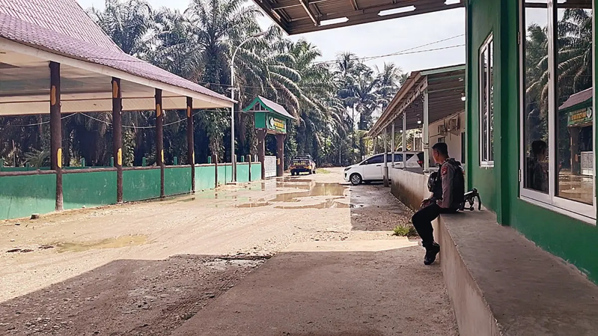 Personel kepolisian bersiaga saat mendampingi Tim Penyidik KPK menggeledah rumah pribadi Bupati Kuantan Singingi nonaktif Suhardiman Amby di Balai Datuk Panglimo Dalam, Desa Pulau Panjang, Kecamatan Inuman, Senin (6/7/2026). (WARGA UNTUK RIAU POS)
