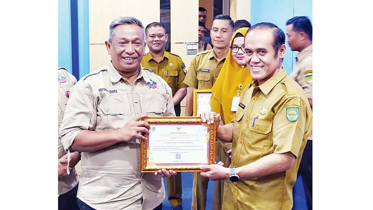 MENYERAHKAN PIAGAM: Bupati Rohul Anton ST MM menyerahkan piagam penghargaan kepada Dirut RSUD Rokan Hulu dr Zuldi Afki SpP atas komitmen dan integritasnya dalam mewujudkan tata kelola pemerintahan yang bersih, sehingga berhasil meraih opini kualitas tinggi tanpa maladministrasi dalam penilaian Pelayanan Publik Tahun 2025 oleh Ombudsman RI, Selasa (7/7/2026). (Prokopim Setda Rohul untuk Riau Pos)