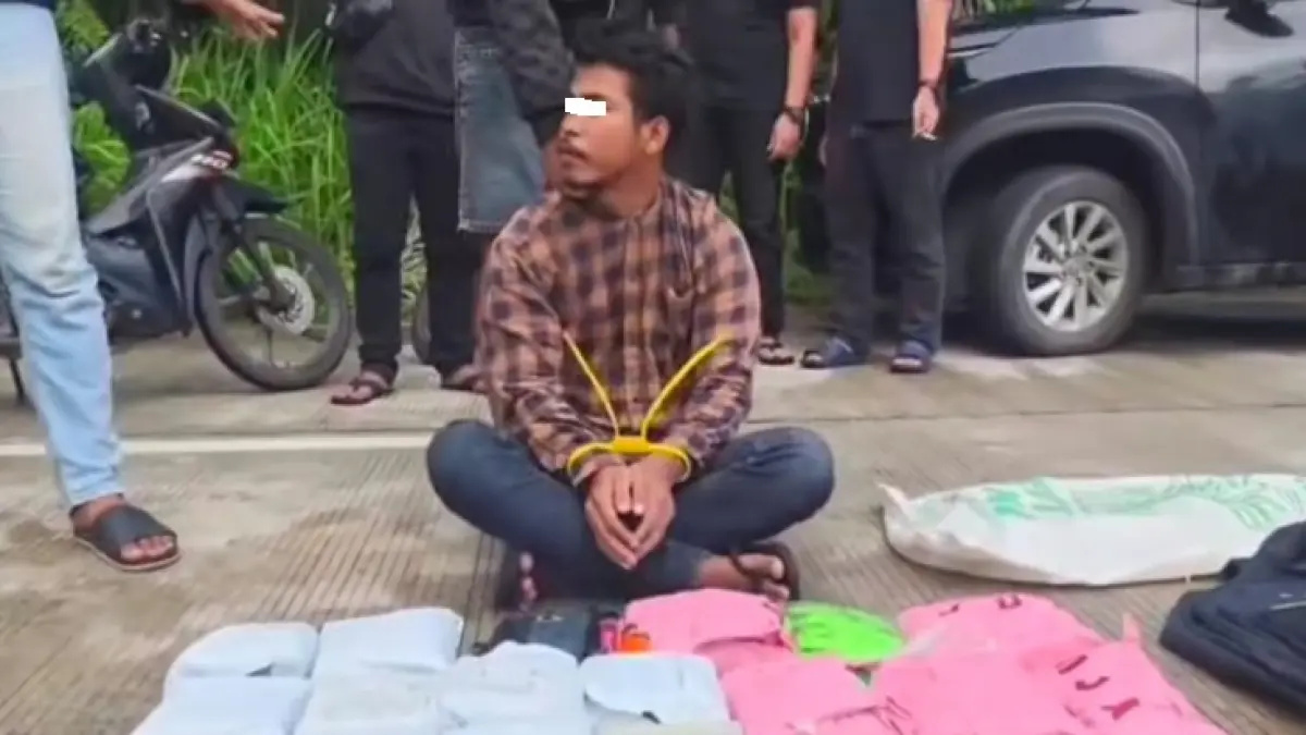 Tersangka SF menunjukkan barang bukti narkotika usai ditangkan&nbsp; di Jalan Utama Ketam, Desa Kelemantan, Kecamatan Bengkalis pada, Ahad (5/7/2026). (Dittipidnarkoba Bareskrim Mabes Polri) 