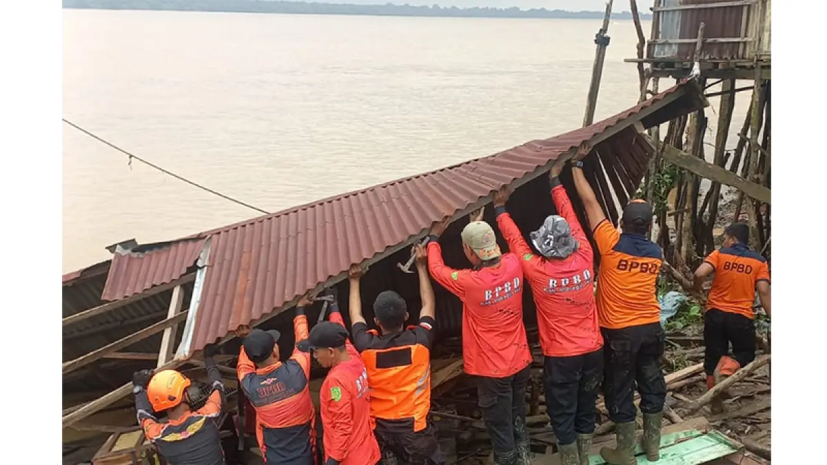Tim BPBD Inhil dibantu warga melakukan evakuasi rumah yang roboh dan miring akibat angin kencang disertai hujan dan gelombang pasang di Tembilahan Hulu, Inhil, Kamis (9/7/2026).(Istimewa)